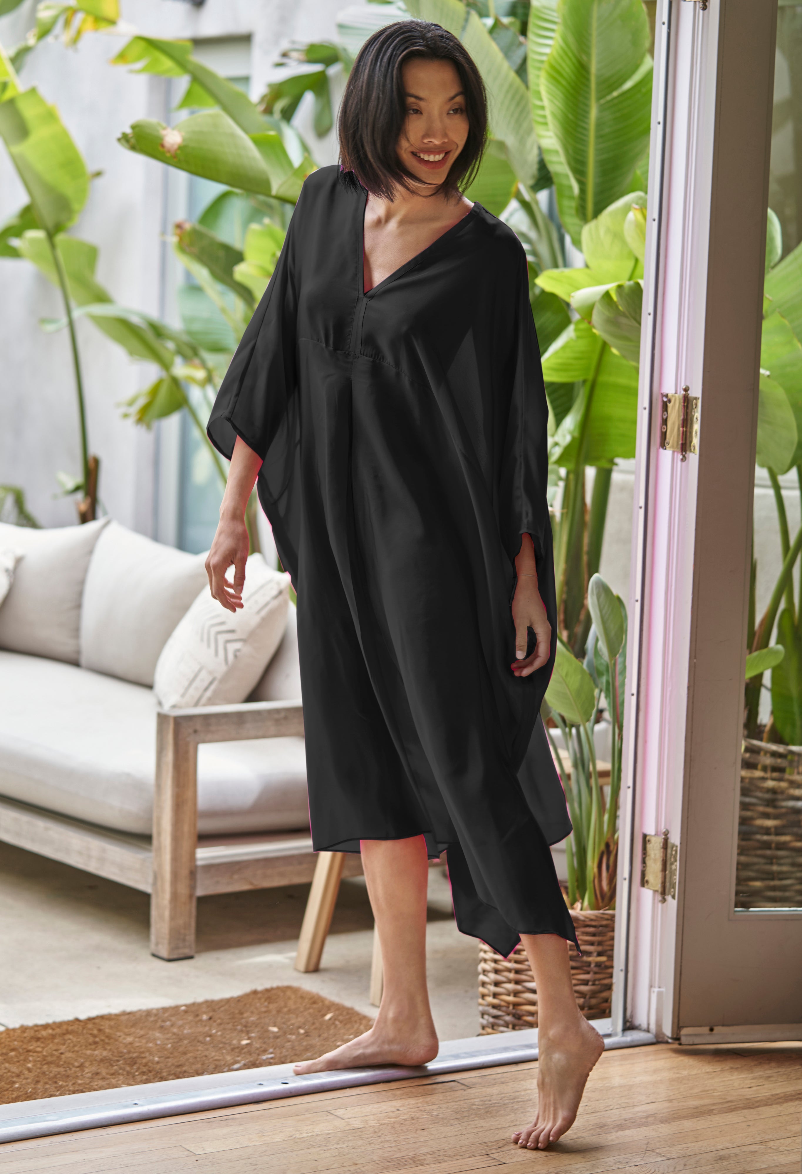 Woman barefoot wearing ocean+main Black Midi Silk Caftan Dress