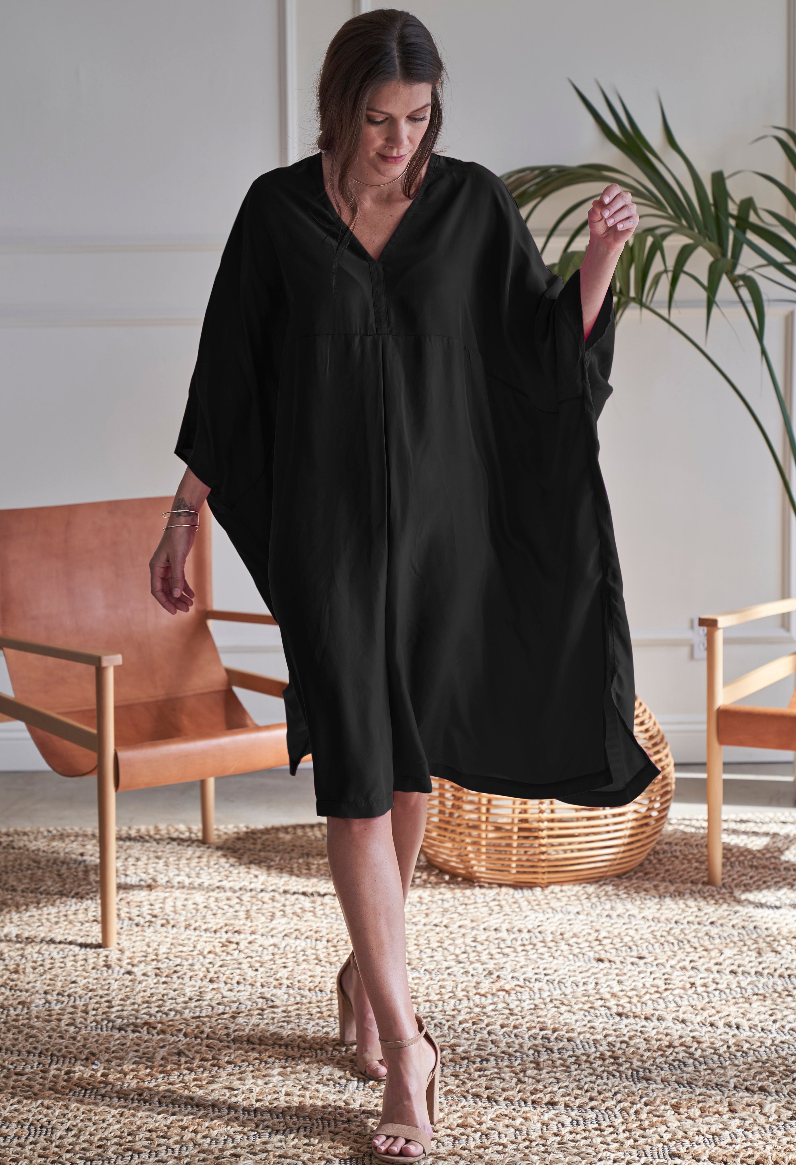 Model walking in ocean+main Black Midi Silk Caftan Dress