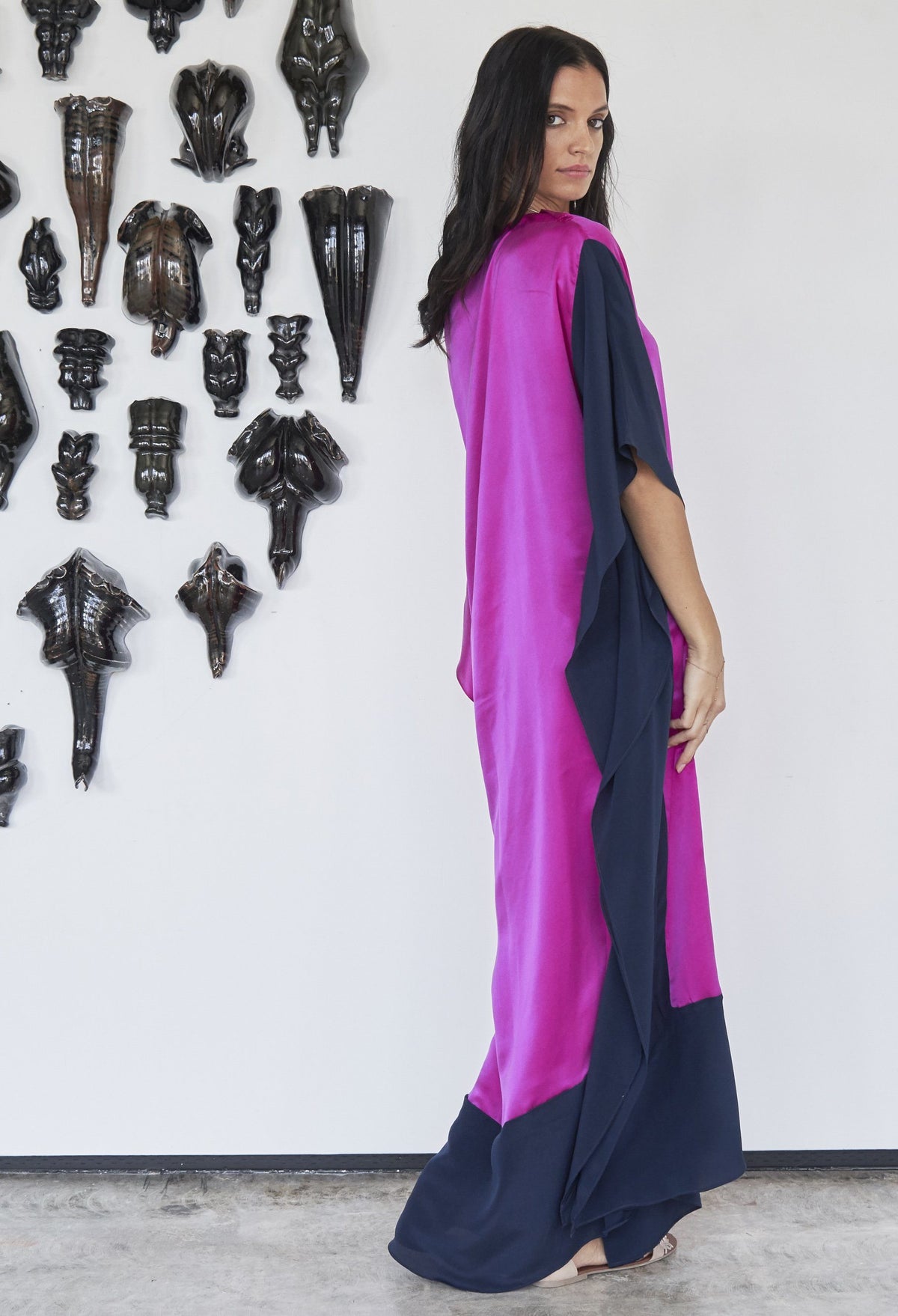 Woman looking back over her shoulder wearing ocean+main Fuchsia And Navy Contrast Boatneck Silk Caftan
